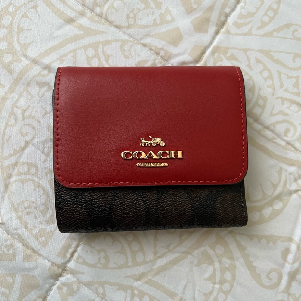Coach small trifold wallet in blocked signature canvas.